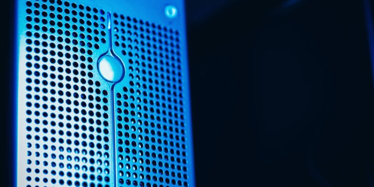 Responsável de TI analisando em dois monitores o painel do servidor local e o painel do ambiente em nuvem da empresa