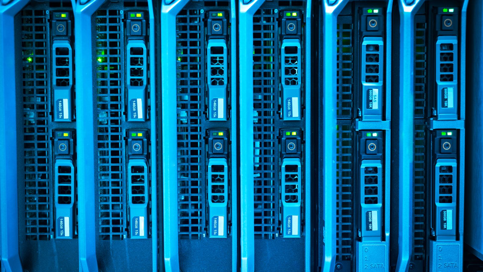 Responsável de TI conferindo o painel de rotina de backup enquanto a equipe da empresa segue operando ao fundo